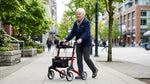Senior woman walking outdoors with a lightweight rollator walker on a Canadian city sidewalk