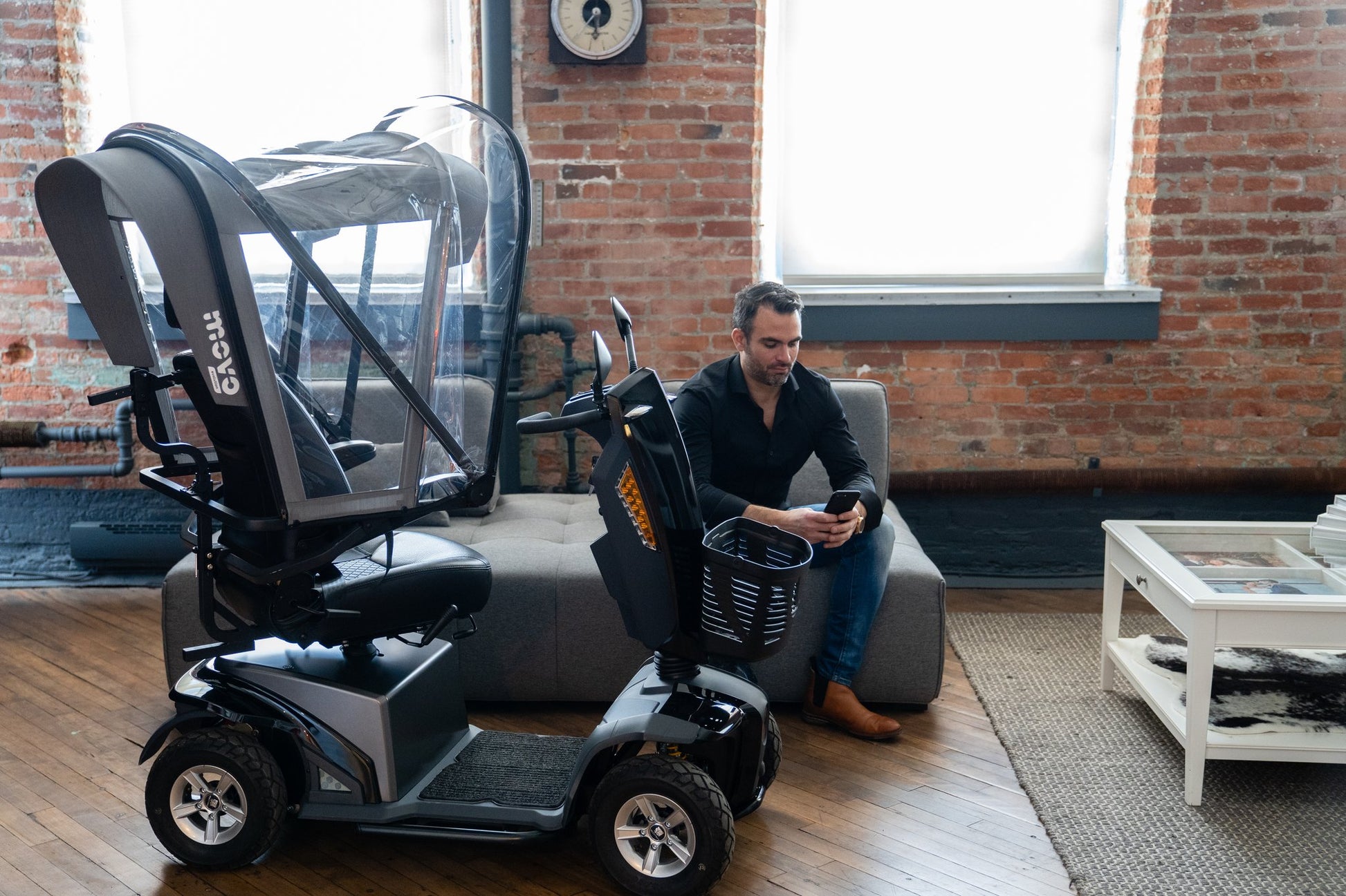 Man seated beside a mobility scooter fitted with the Movo Canopy retracted