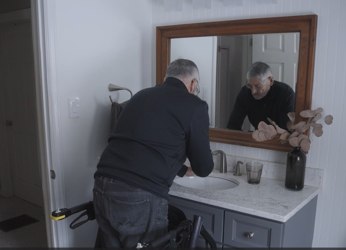 RAYMEX Lift Quattro used as a standing aid at a bathroom sink and vanity