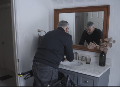 RAYMEX Lift Quattro used as a standing aid at a bathroom sink and vanity
